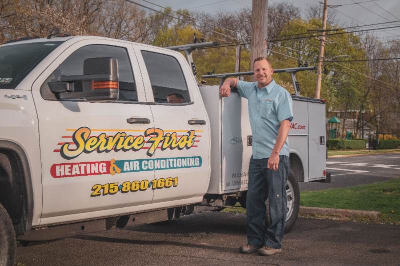 Owner Of Service First Brian Next To Company Truck